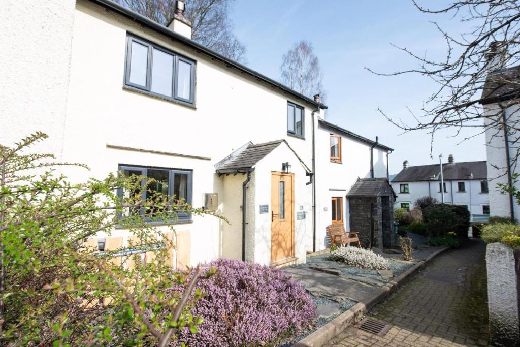 a white house with a pathway leading to it at Green Beck Cottage, within walking distance of the lake, shops, pubs & restaurants of Coniston in Coniston