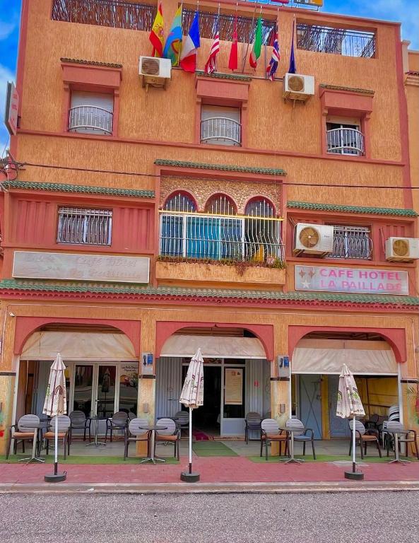 a building with tables and chairs in front of it at La paillade in Oulad Barrehil