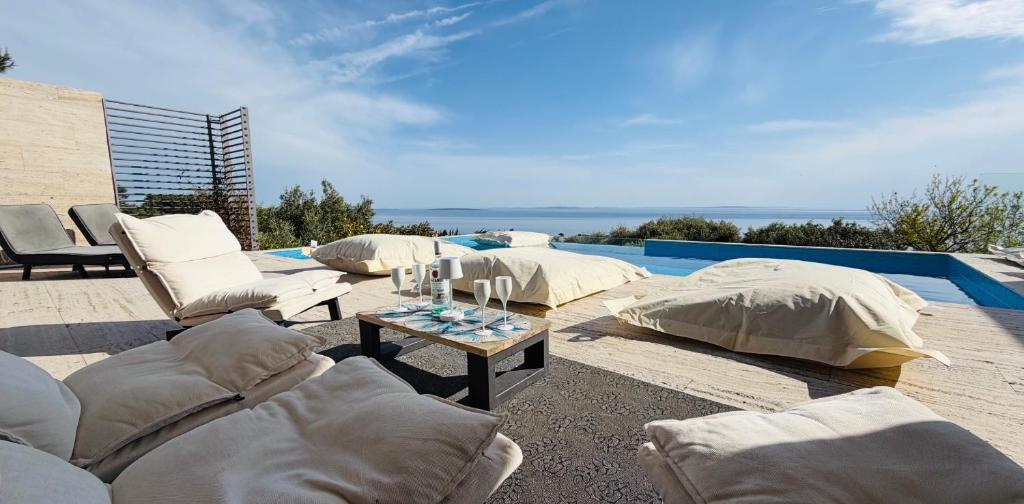 a patio with couches and a table next to a pool at Luxury Villa Nova, Pag in Novalja