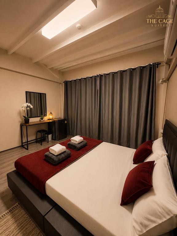 a bedroom with a large bed with two pillows on it at The Cage Suites in Bangkok