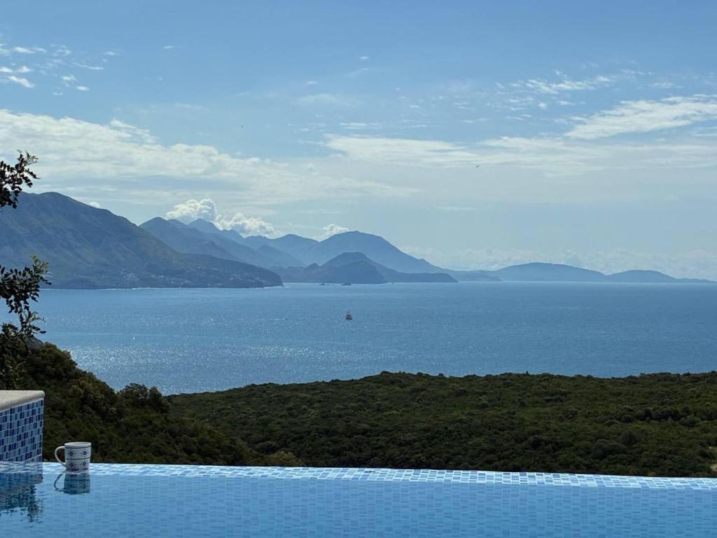 a swimming pool with a view of the water and mountains at Carob Breeze House in Krimovice