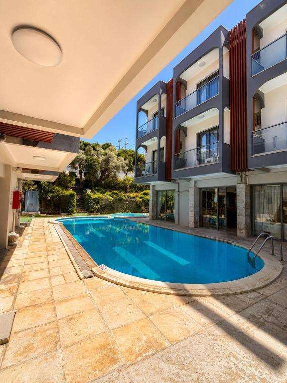 a swimming pool in front of a building at Calis Hotel in Çeşme