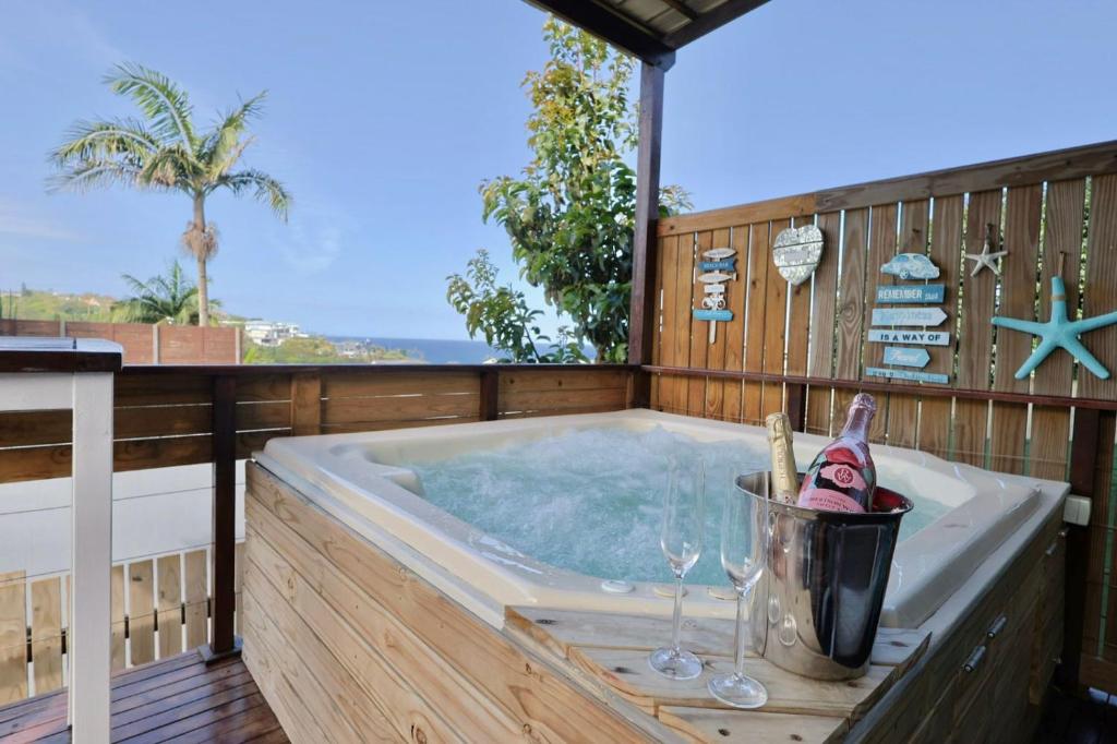 a hot tub on a deck with wine glasses at Breakers View in Sheffield Beach