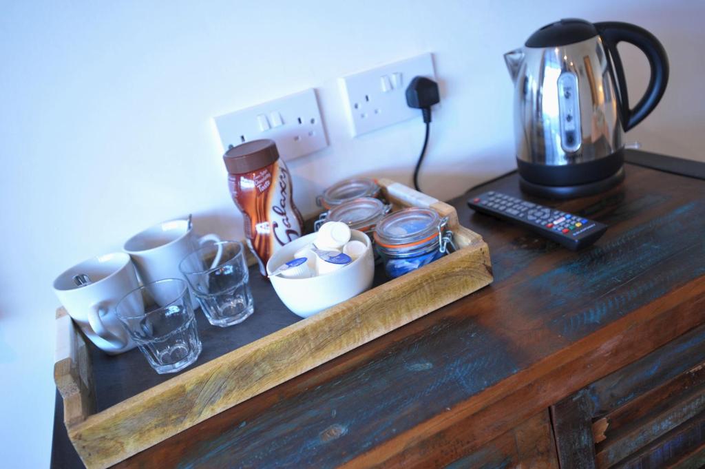 a wooden table with cups and a coffee maker on it at Sea View Guest House in Benllech