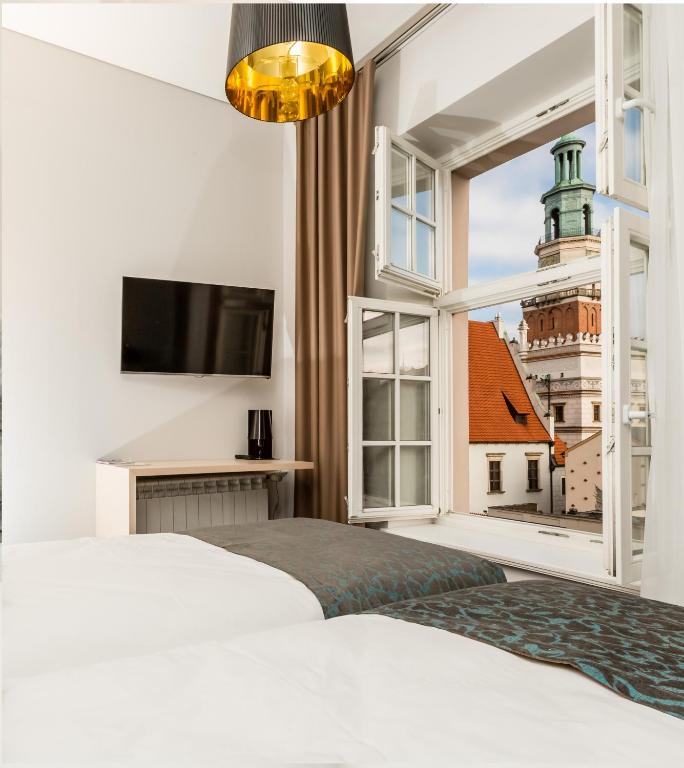 a bedroom with a white bed and a window at Sleep in Hostel & Apartments Stary Rynek in Poznań