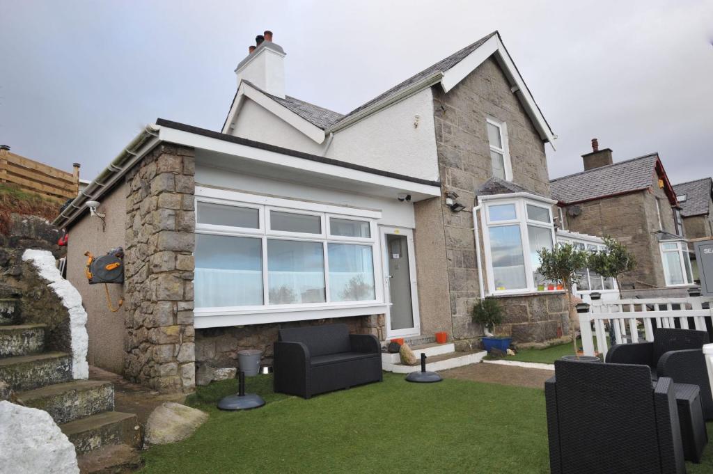 a house with a lawn in front of it at Sea View Guest House in Benllech