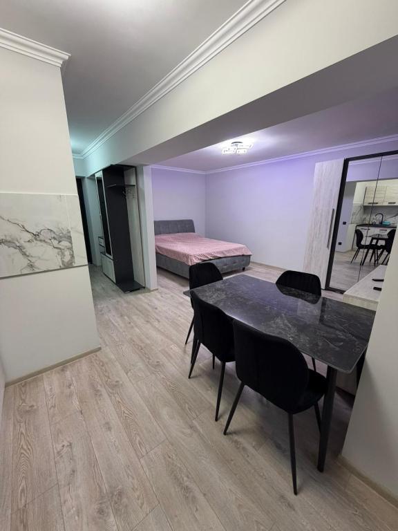 a room with a table and chairs and a bed at Apartament Rîșcani in Chişinău