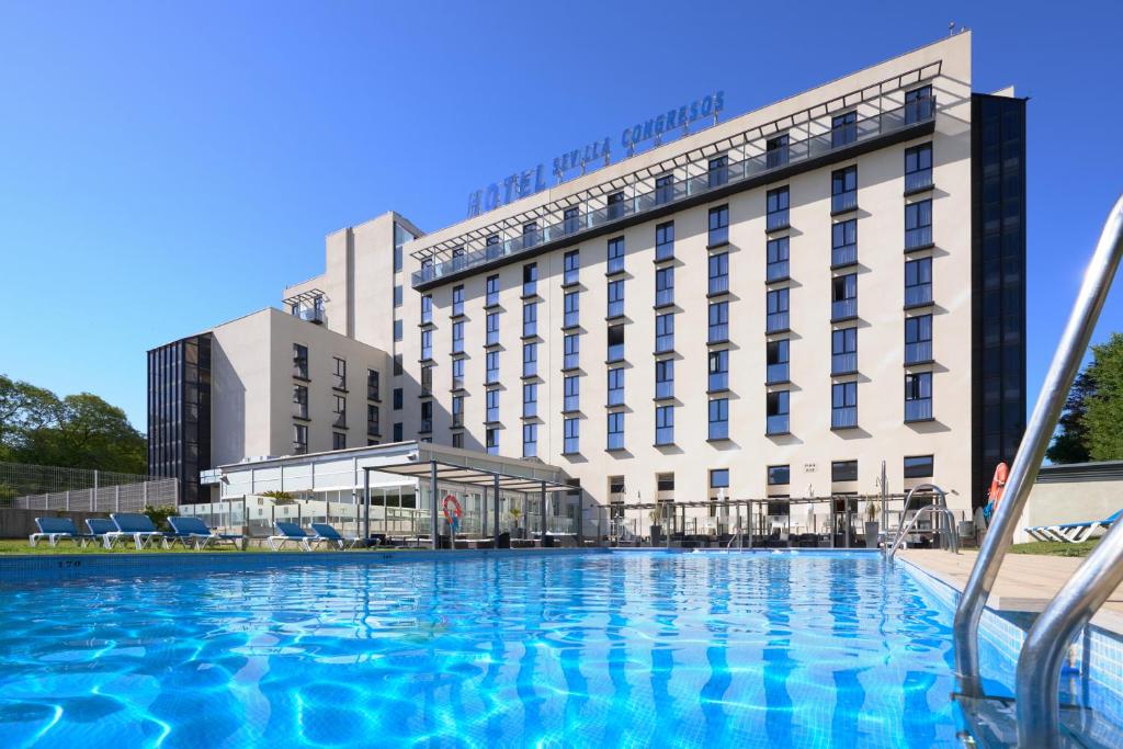 a large swimming pool in front of a hotel at M.A. Hotel Sevilla Congresos in Seville