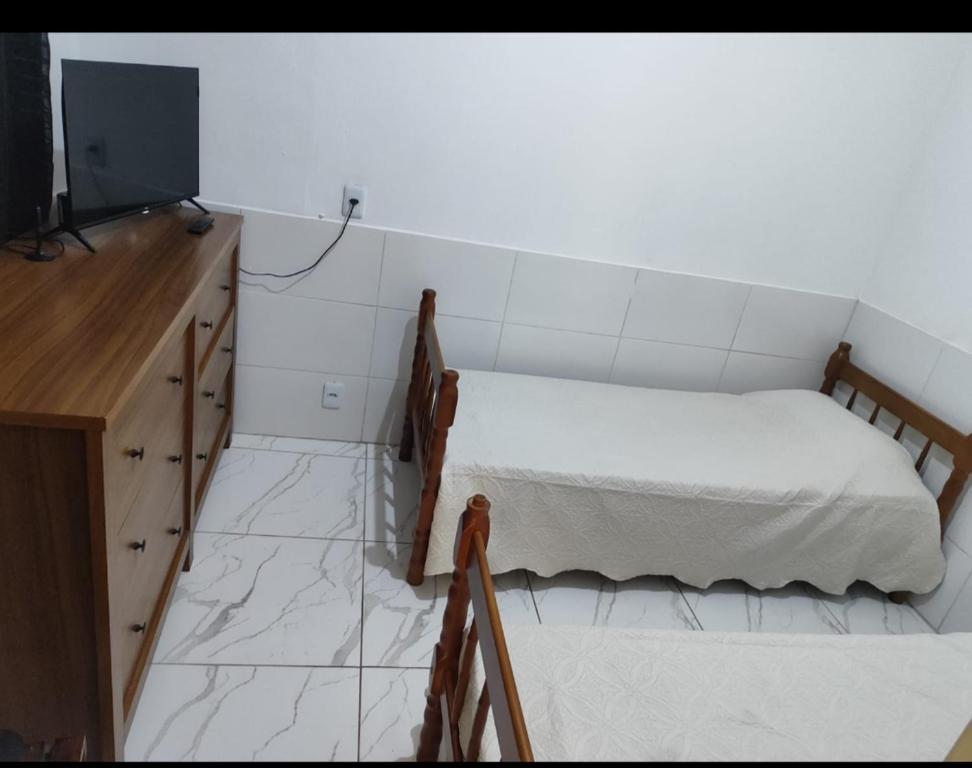 a small bedroom with a bed and a television at Kit net familiar in Vitória