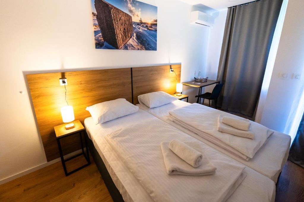 a bedroom with two beds with towels on them at Apartmani Narona in Jablanica