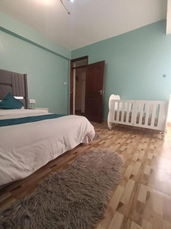 a bedroom with a bed and a rug on a wooden floor at The Cliff in Nairobi