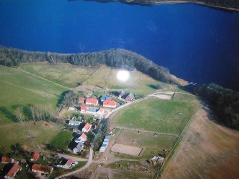an aerial view of a house on a hill next to the water at Ferienwohnung am Kreßinsee in Strietfeld