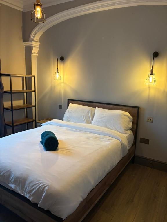 a bedroom with a bed with a hat on it at Impressive City Centre Apartment in Derby