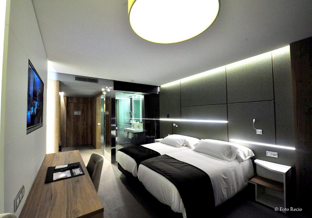 a bedroom with a large bed and a table at Hotel & Spa Ciudad de Binéfar in Binéfar