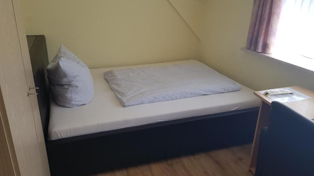 a small bed with two pillows on it in a room at Bastan - Haus Katharina in Emden