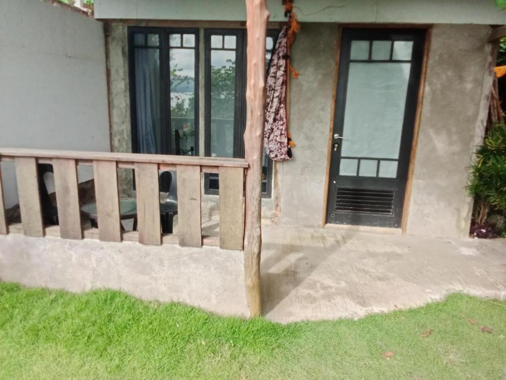 a house with a wooden fence and a door at MountainSide Lodge in El Nido