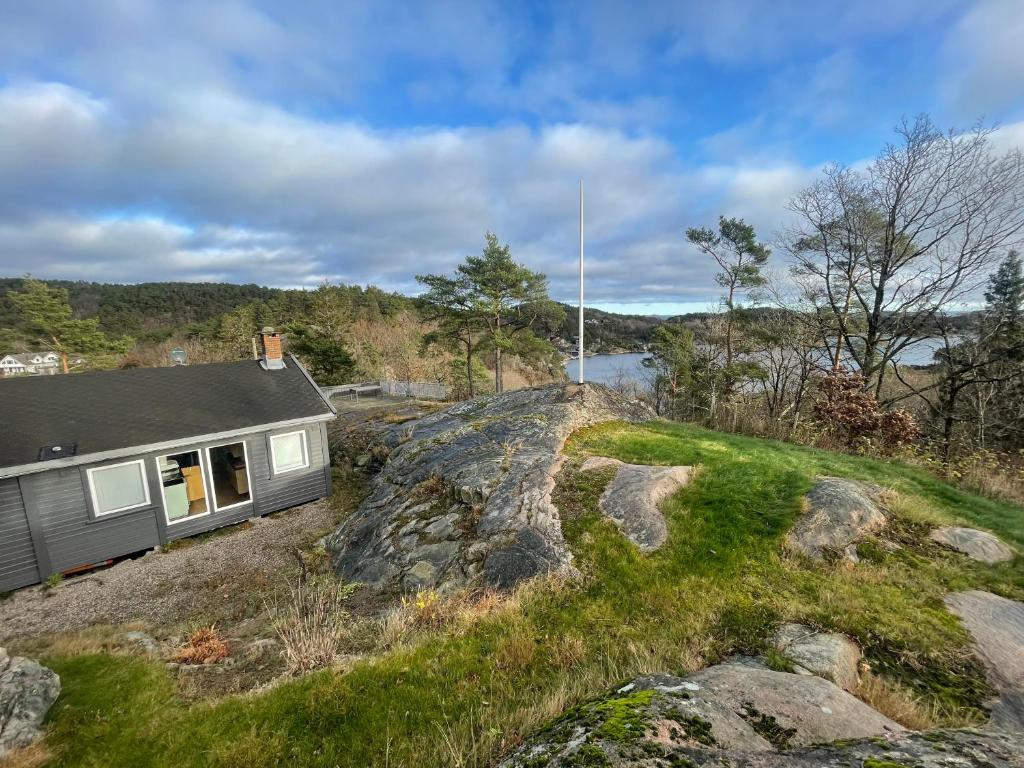 a small house on top of a rocky hill at Havblikk, cozy cabin by the sea with beautiful views in Mandal