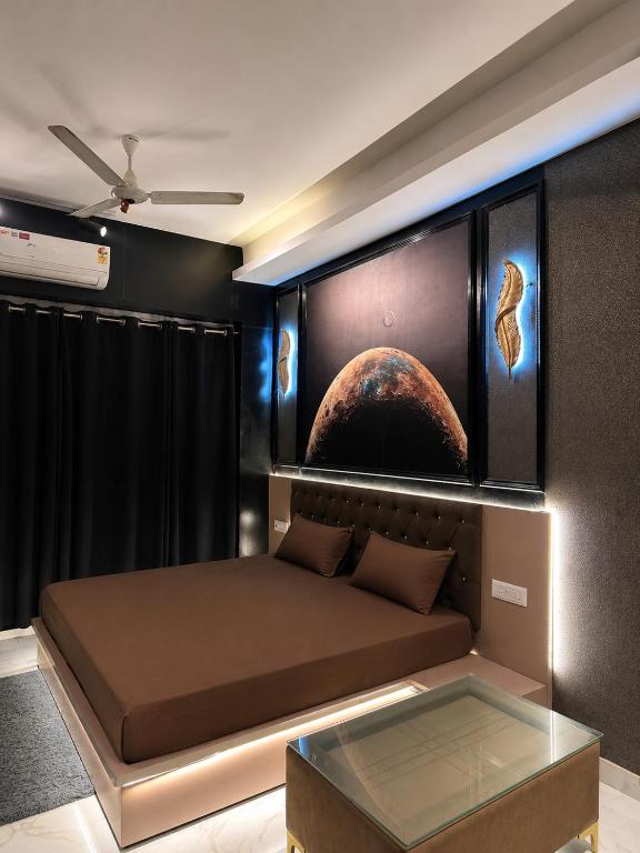 a room with a bed with a planet mural on the wall at Moon Escape Studio in Ghaziabad