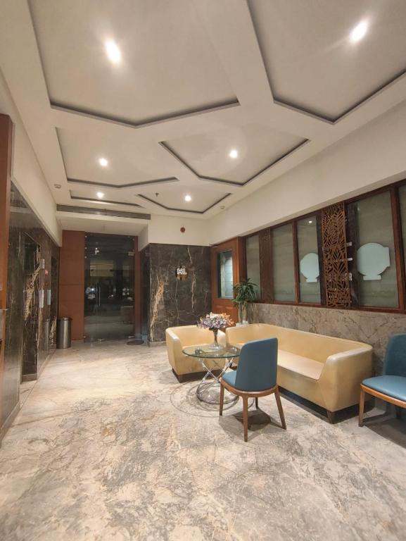 a lobby with a couch and a table and chairs at Shelter Suites - Formerly known as Fisco The Hub Link in Mumbai