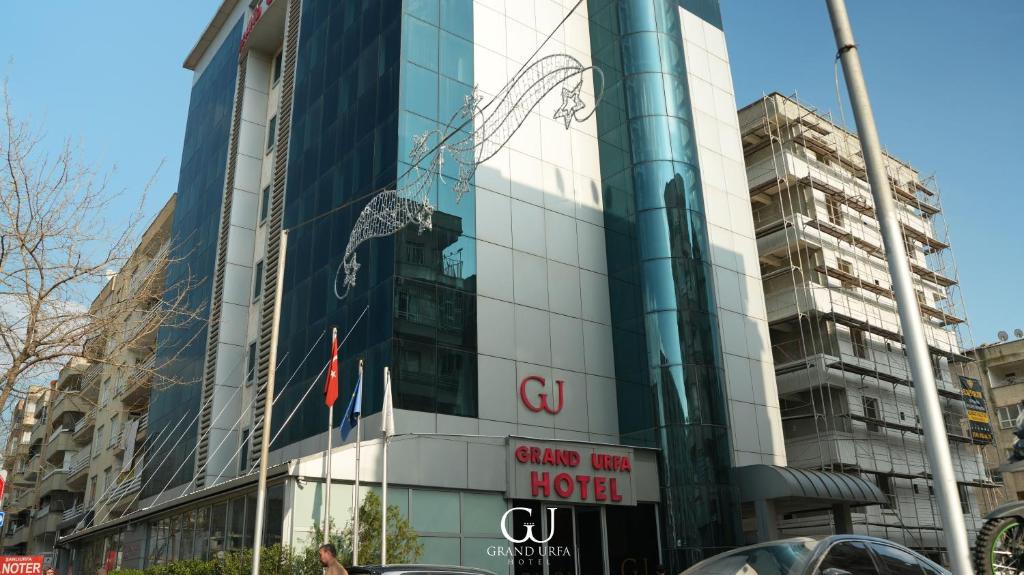 a building with a sign in front of it at Grand Urfa Hotel in Urfa