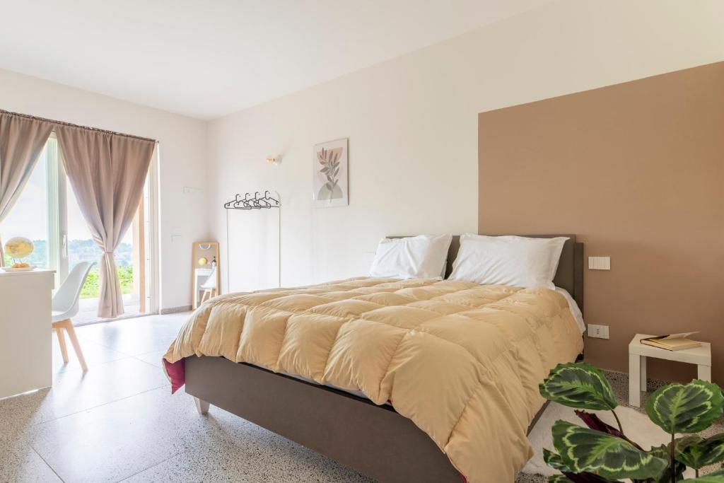 a bedroom with a large bed and a large window at Lanizoladelroero in Sommariva Perno