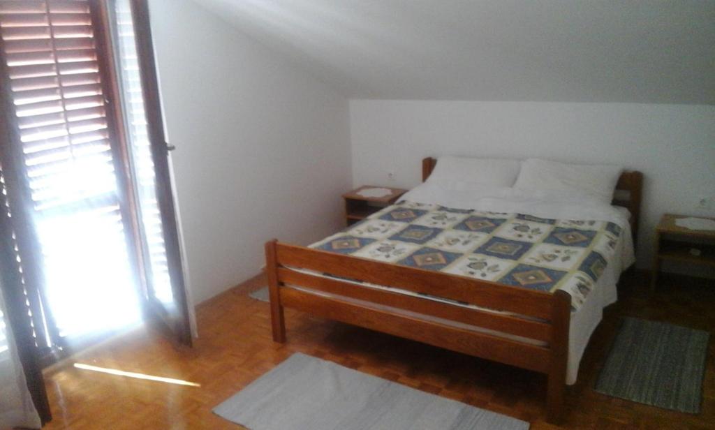 um pequeno quarto com uma cama e uma janela em Apartment Rogić em Biograd na Moru