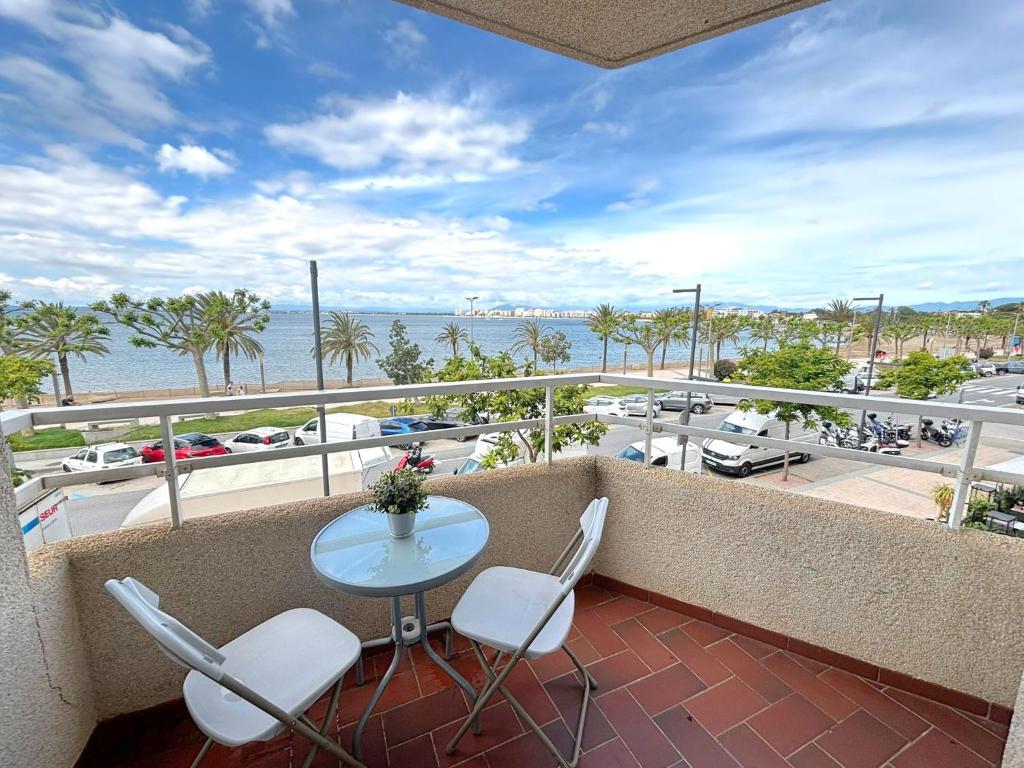 a balcony with a table and chairs and a view of a harbor at Rhode 1b in Roses