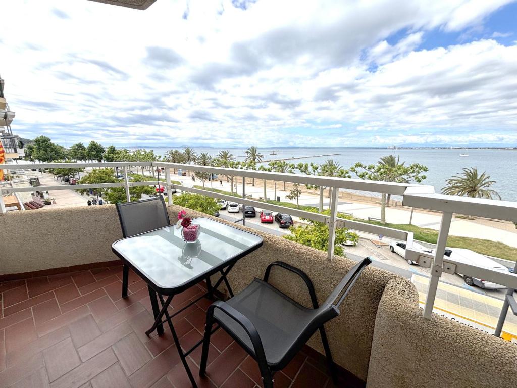 a balcony with a table and chairs and a view of the ocean at Rhode 2a in Roses