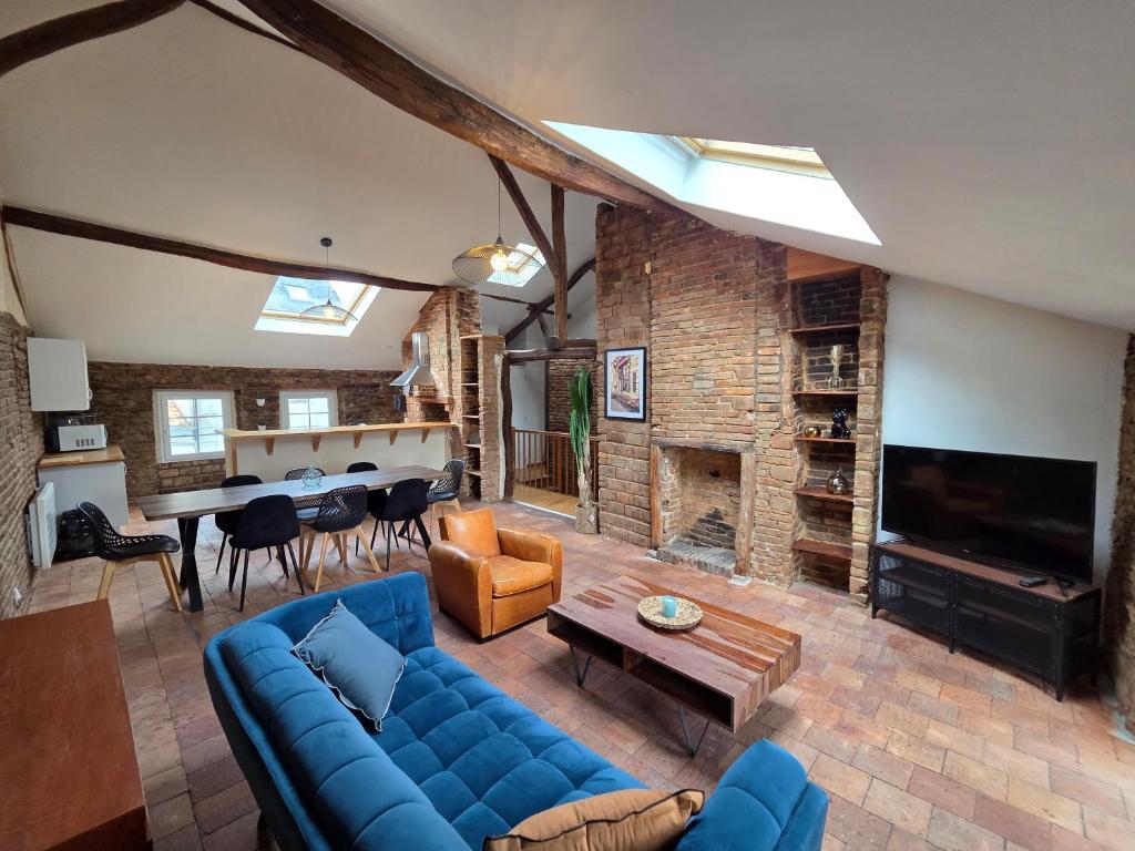 a living room with a blue couch and a fireplace at Les terrasses de la moine in Cholet