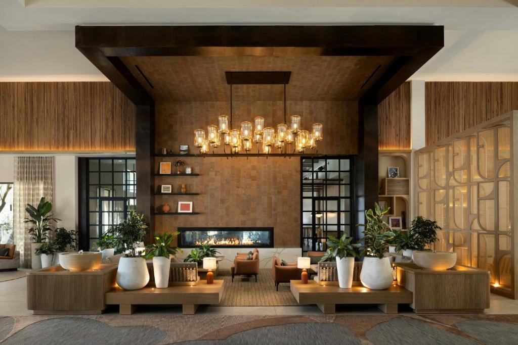 a living room with a fireplace and a chandelier at Hotel Solea, Autograph Collection in Carlsbad
