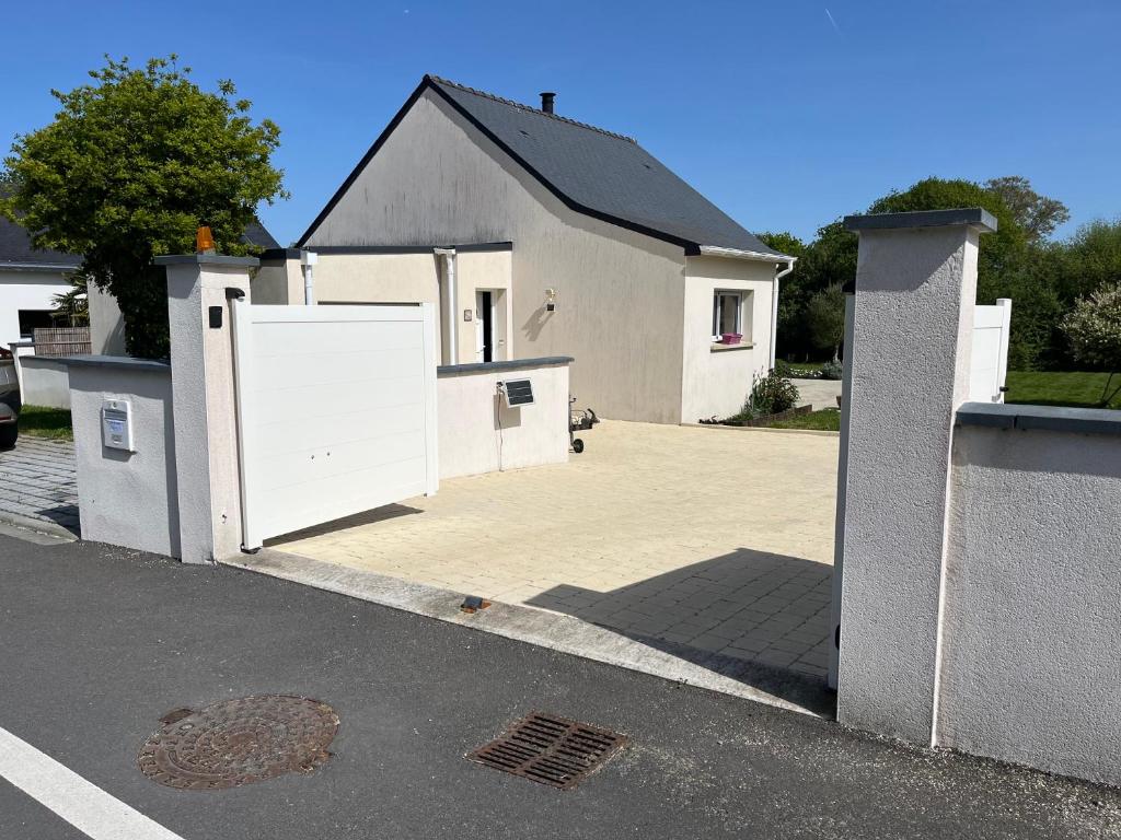 a white house with a white door in a driveway at Gîte Ghislaine in Péaule