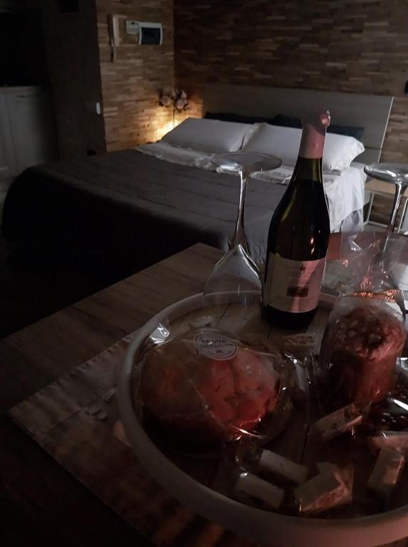 a bottle of wine on a table next to a bed at La Piemontesina in Nizza Monferrato
