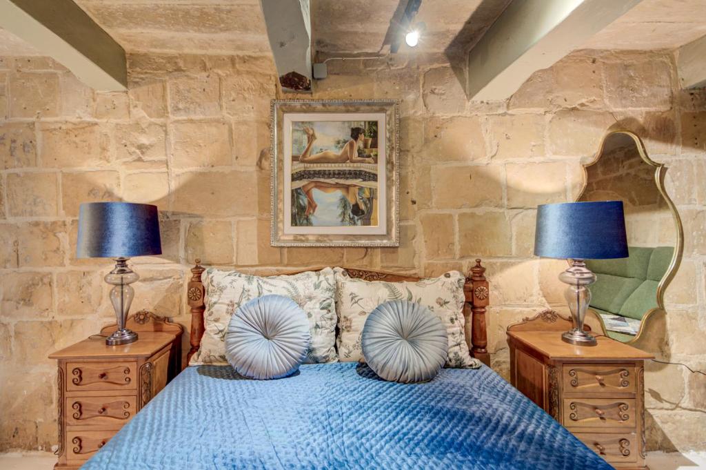 a bedroom with a blue bed with two lamps at Valletta Boutique Residence in Valletta