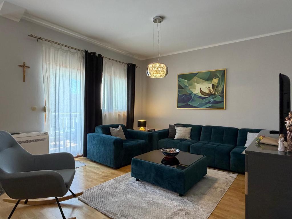 a living room with a blue couch and a table at Apartman Emaus in Međugorje
