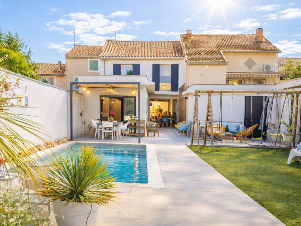 a backyard with a swimming pool and a house at Grande Maison familiale - Piscine privée & Jardin clos - 10min Avignon & Château-neuf-du-Pape - Climatisation - Parking privé gratuit - Animaux admis in Sorgues