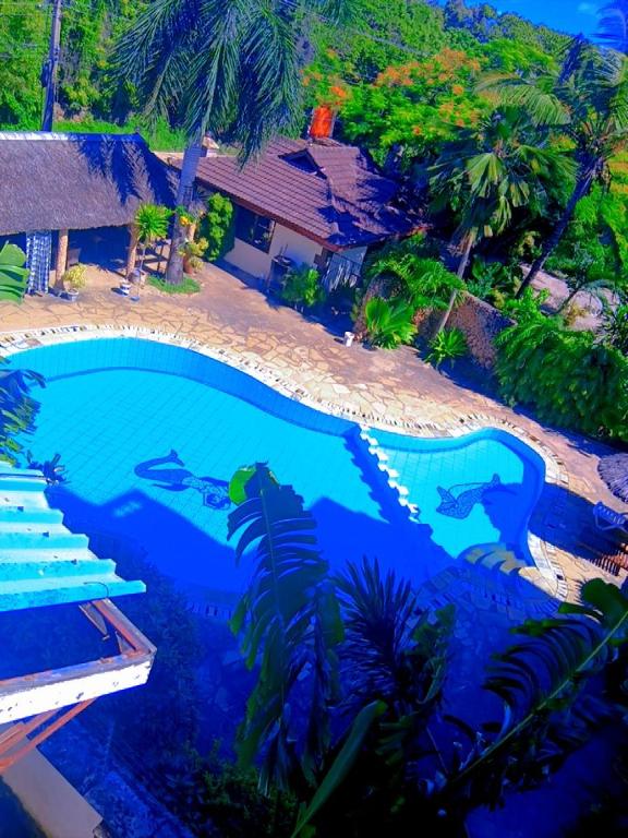 a large blue swimming pool in front of a house at Pebs one bedroom apartment in Mombasa