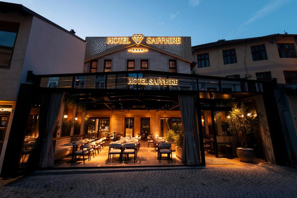 a restaurant with tables and chairs in front of a building at Sapphire Hotel in Prizren