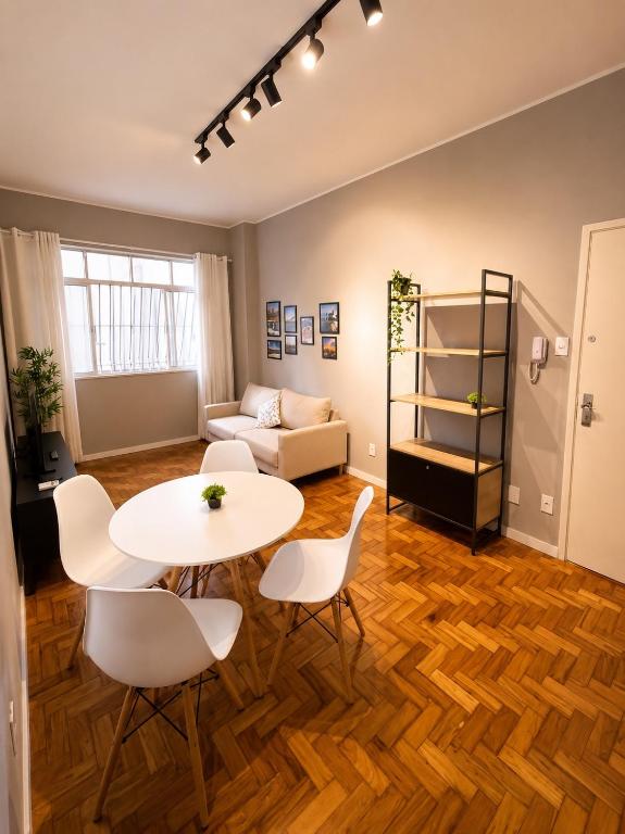 a living room with a table and chairs and a couch at Apartamento Nictheroy in Niterói