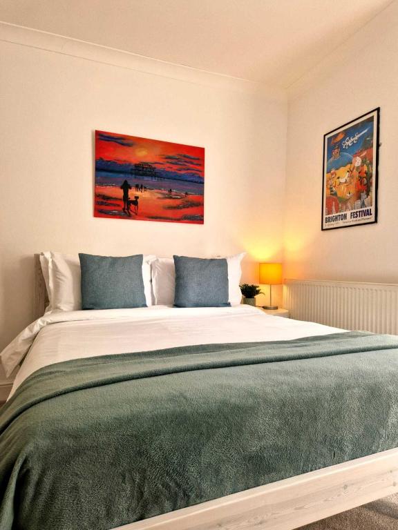a bedroom with a large bed with a green blanket at Upper Rock Brighton – Guest House in Brighton & Hove