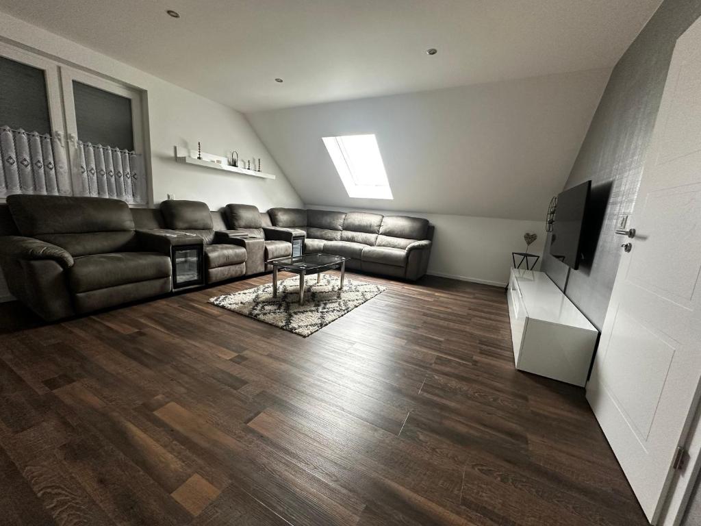 a living room with a leather couch and a television at Ferienhaus Kronseeliebe in Lychen
