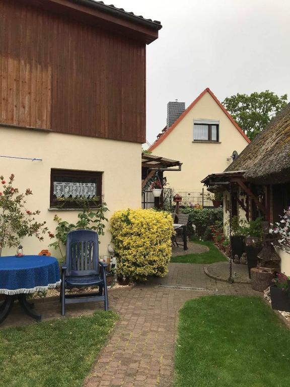 a house with a blue chair in a yard at Csajka FeWo in Ueckeritz