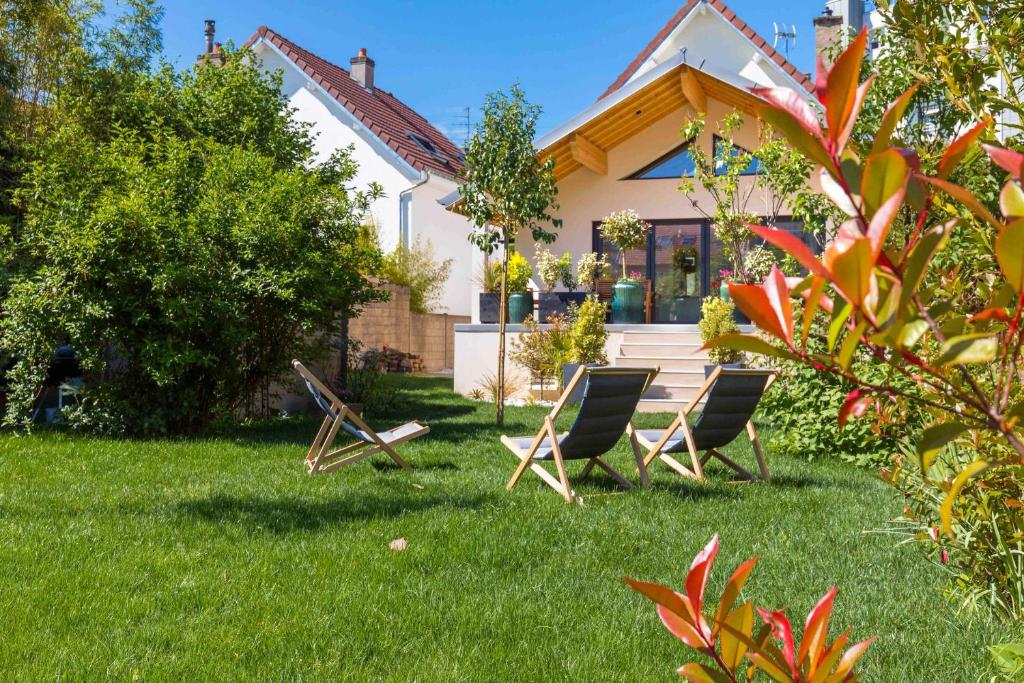 two chairs in the grass in front of a house at La Balzac in Dijon