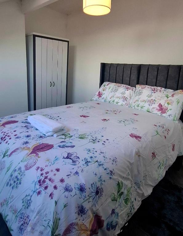 a bedroom with a bed with a floral bedspread at Stratford Terrace in Beeston