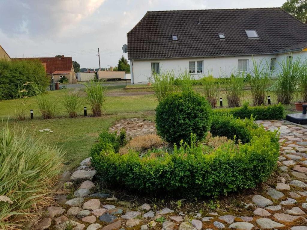 a garden in front of a white house at Pribbenower Ferienhaus in Pribbenow