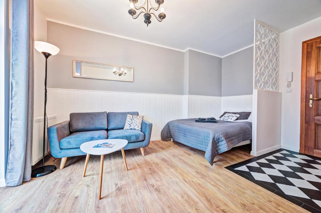 1 dormitorio con sofá, cama y mesa en Nobilit Apartamenty, en Poznan