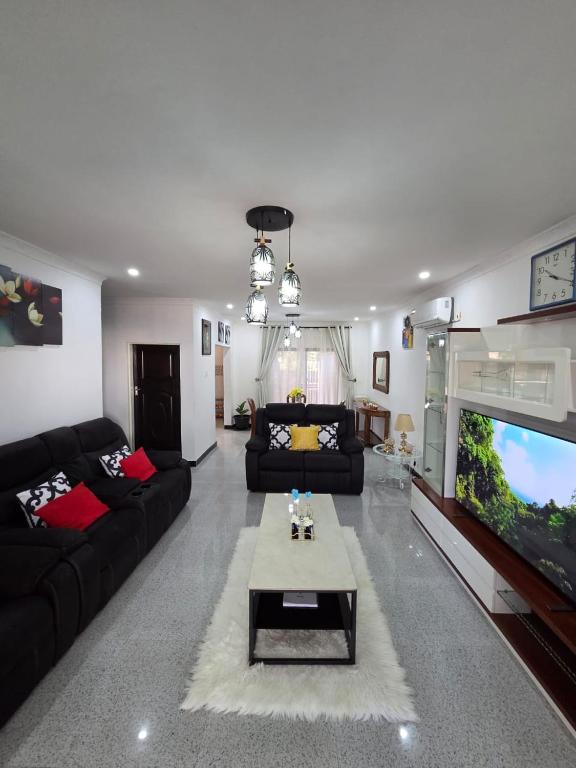 a living room with a couch and a tv at Mel's Apartment in Ndola