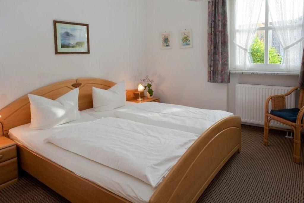 a bedroom with a large bed with white sheets at Störtebeker 07 in Kühlungsborn