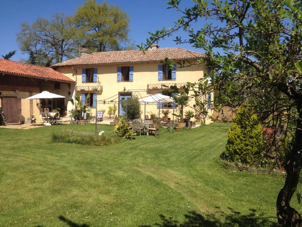 a large house with a yard with green grass at Domaine Le Chec in Saint-Ost