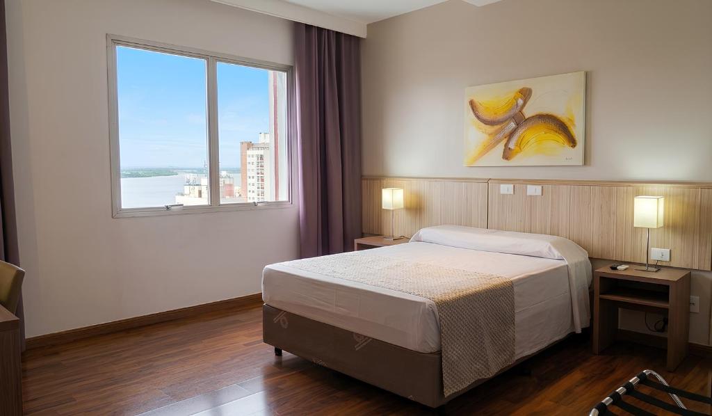 ein Hotelzimmer mit einem Bett und einem Fenster in der Unterkunft Hotel Nacional Inn Porto Alegre - Próximo ao Complexo Santa Casa e Araújo Viana in Porto Alegre