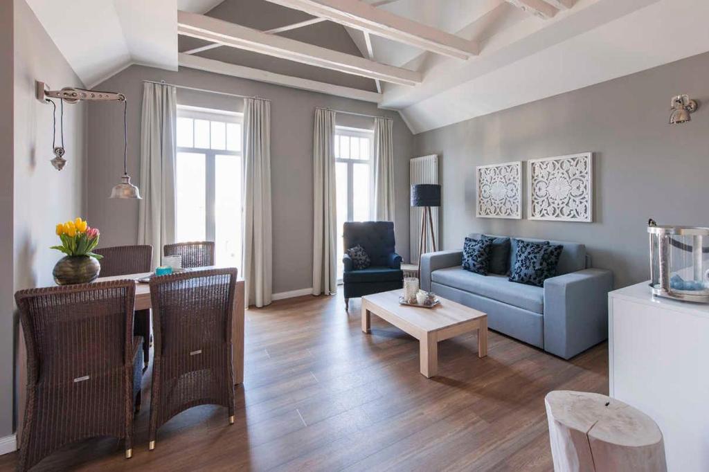 a living room with a blue couch and a table at "Villa Minerva" Ferienwohnung 09 in Kühlungsborn